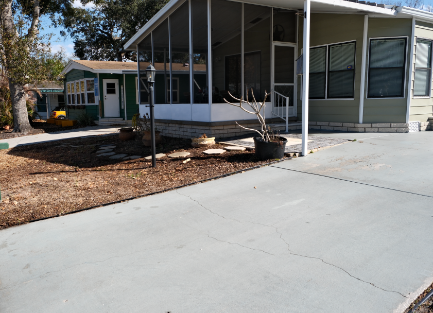 Paved driveway leading to a house with a screen porch